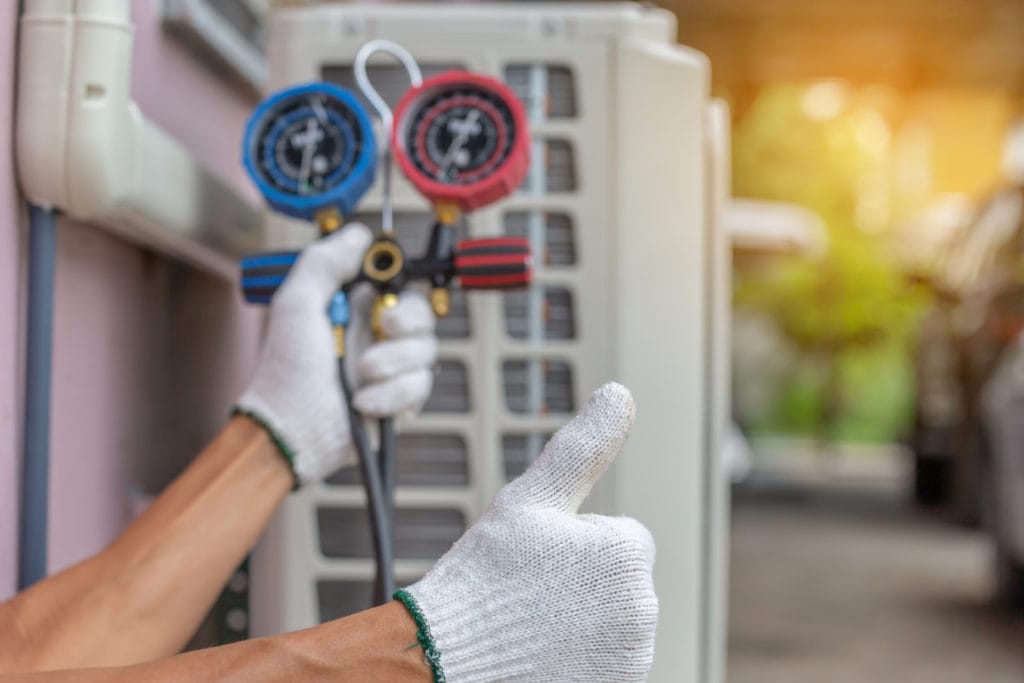 Close up of Air Conditioning Repair, repairman on the floor fixing air conditioning system.