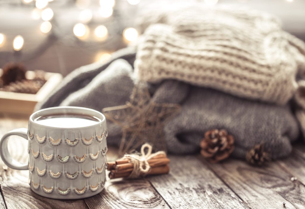 Details of still life in the home interior living room. Beautiful tea Cup and shoes on wooden background . Cozy autumn-winter concept.