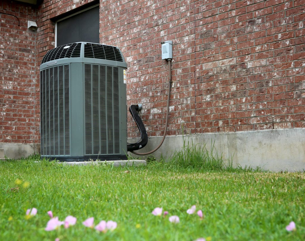 High efficiency modern AC-heater unit on brick wall background.