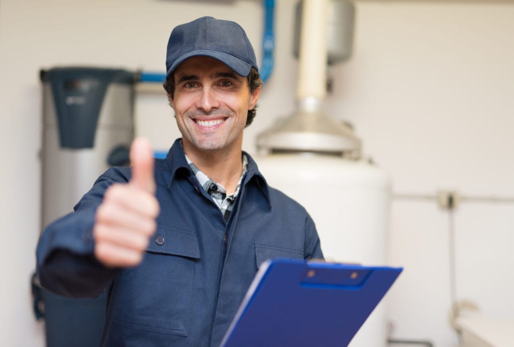 Smiling technician servicing a hot-water heater.