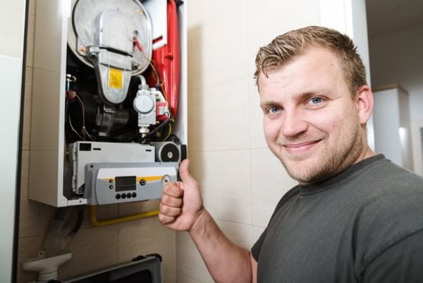 Image of a technician working on a furnace. What Safety Measures Should I Take for My Heating and Cooling System?