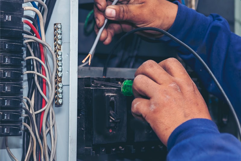 Upgrade Your Outdated Electrical Panel. An electrician working on a panel.