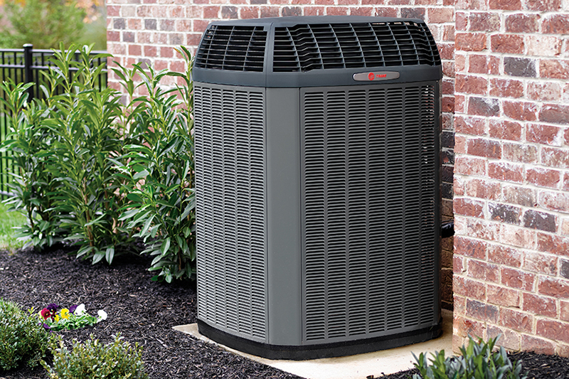 Air conditioning unit outside a brick home.