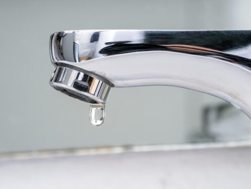 What Problems Can a Leaky Faucet Cause? Drop of water falling from faucet.