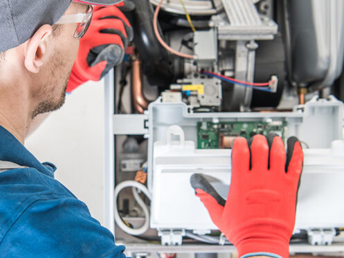 Schedule Your Annual Furnace Inspection Now. A technician inspecting a furnace.